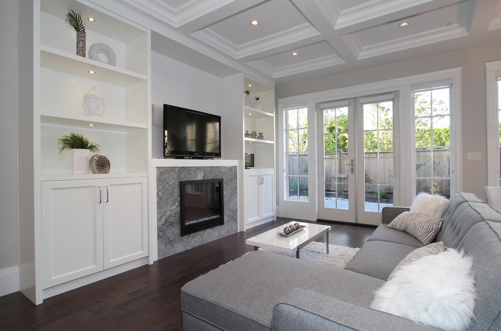 Photo of a large classic open plan games room in Vancouver with grey walls, dark hardwood flooring, a standard fireplace, a stone fireplace surround and a freestanding tv.