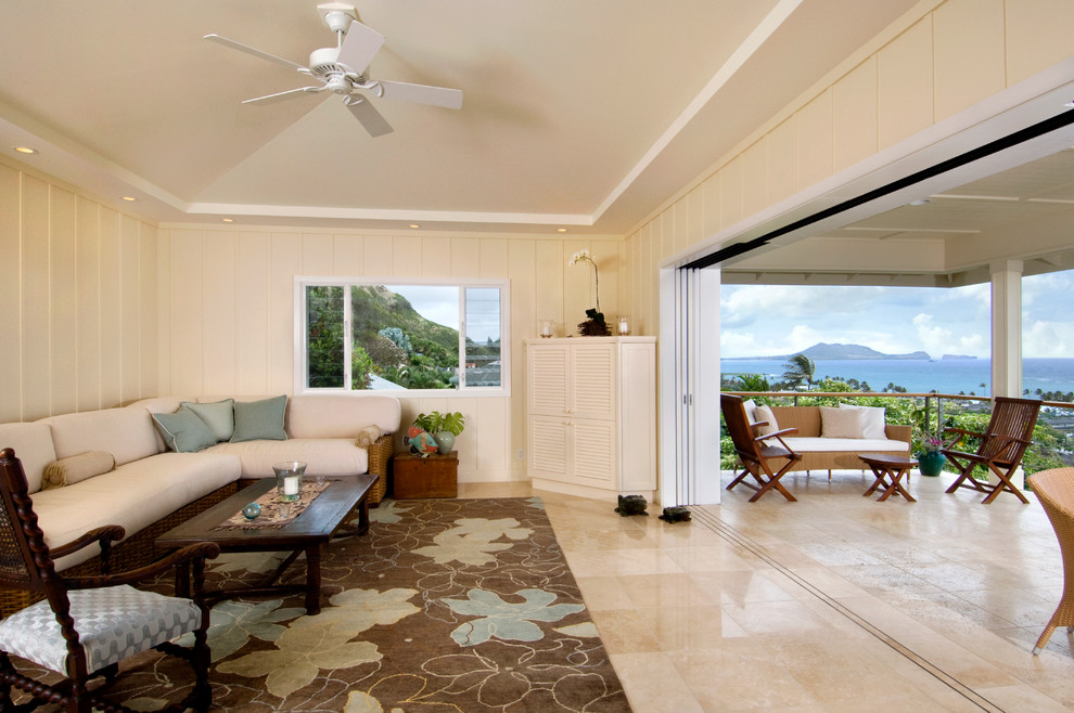 Foto de sala de estar abierta exótica de tamaño medio con paredes beige, suelo de piedra caliza y pared multimedia