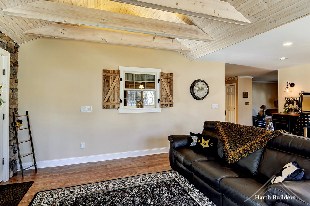 Idées déco pour une salle de séjour campagne de taille moyenne et ouverte avec un mur beige, un sol en bois brun et un téléviseur fixé au mur.