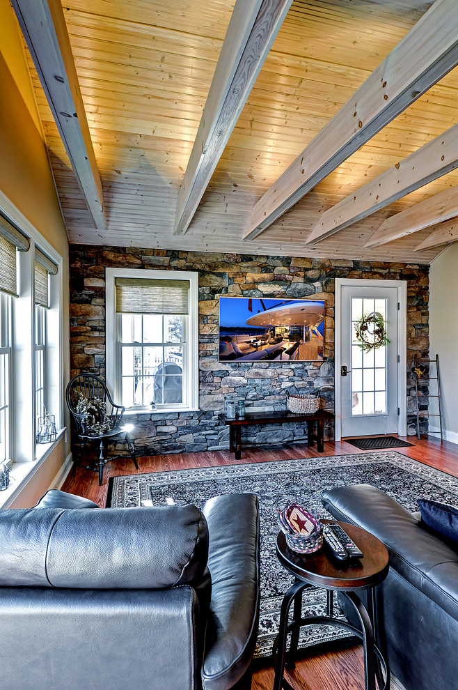 Modelo de sala de estar abierta de estilo de casa de campo de tamaño medio con paredes beige, suelo de madera en tonos medios y televisor colgado en la pared