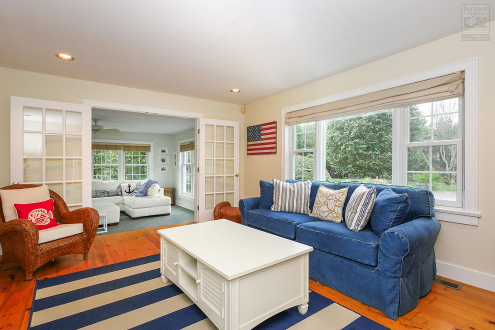 Foto di un grande soggiorno aperto con pareti beige, pavimento in legno massello medio e pavimento multicolore