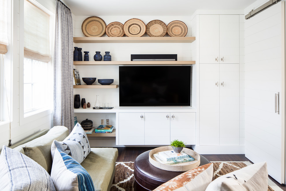 Источник вдохновения для домашнего уюта: гостиная комната в стиле кантри с белыми стенами, темным паркетным полом, телевизором на стене и коричневым полом