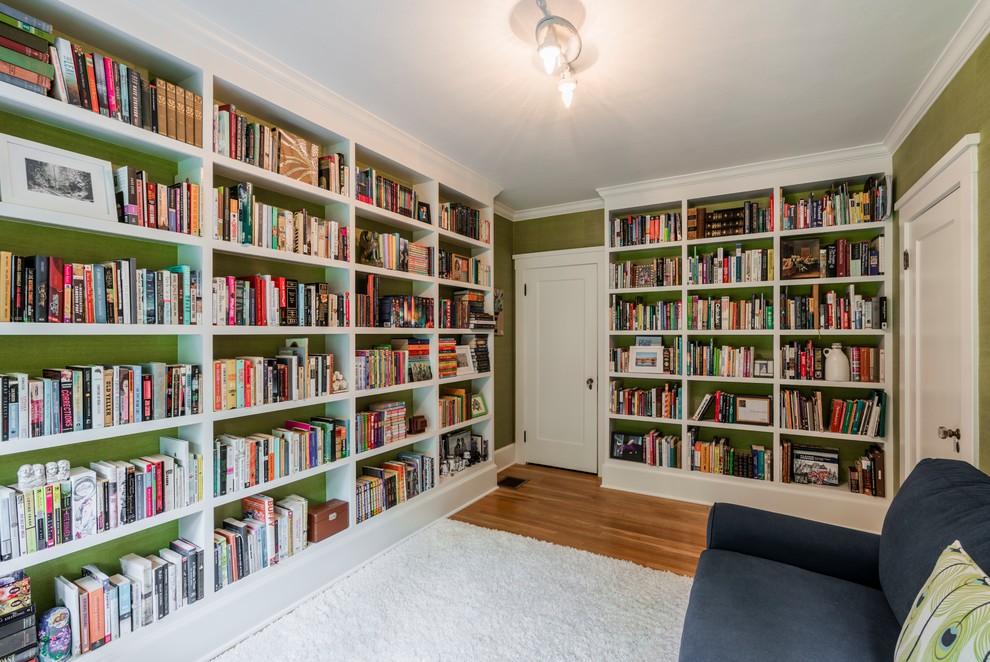 Diseño de sala de estar con biblioteca cerrada tradicional de tamaño medio sin chimenea y televisor con paredes verdes, suelo de madera en tonos medios y suelo marrón