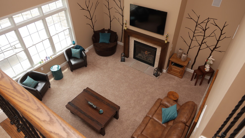 This is an example of a large classic open plan games room in Other with beige walls, carpet, a standard fireplace, a stone fireplace surround and a wall mounted tv.