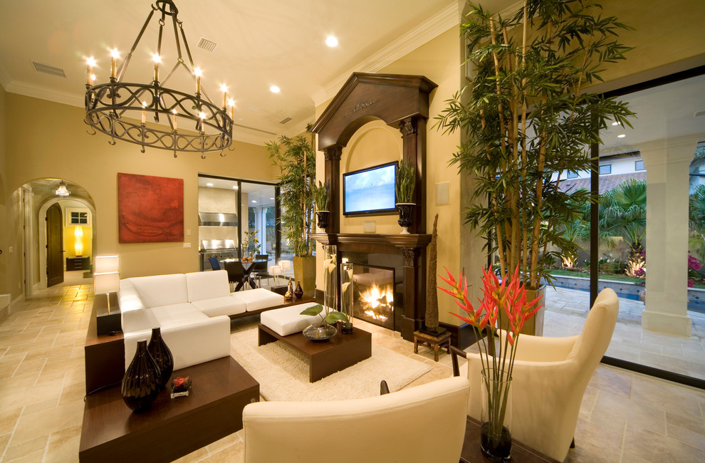 Пример оригинального дизайна: открытая гостиная комната в средиземноморском стиле с желтыми стенами, стандартным камином, фасадом камина из дерева и телевизором на стене