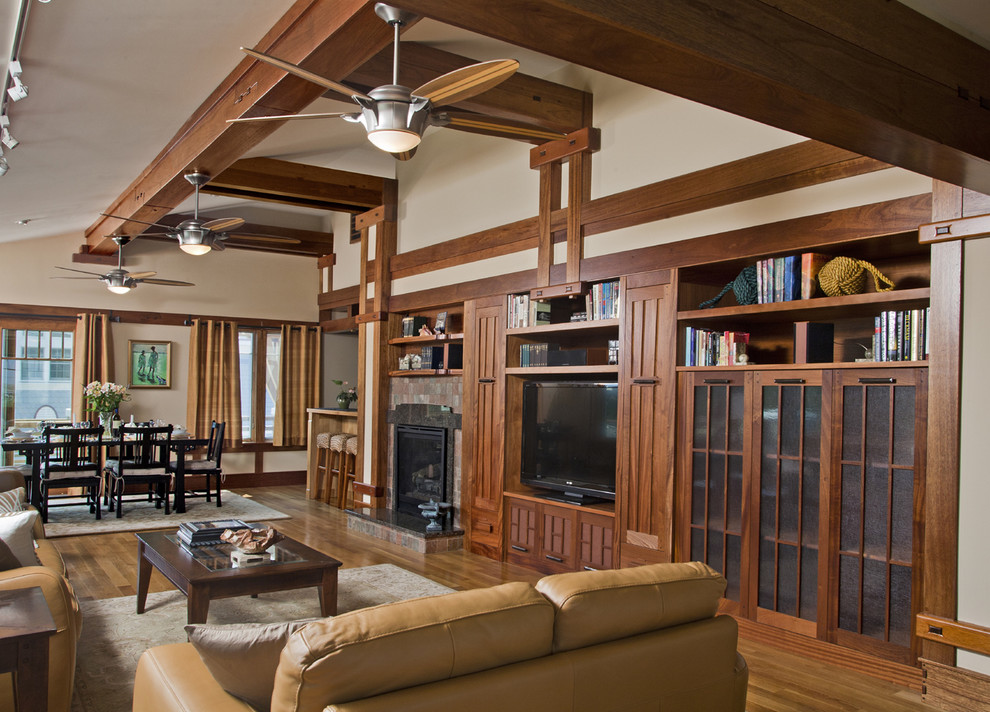 Ispirazione per un soggiorno american style aperto con pareti beige, pavimento in legno massello medio e parete attrezzata