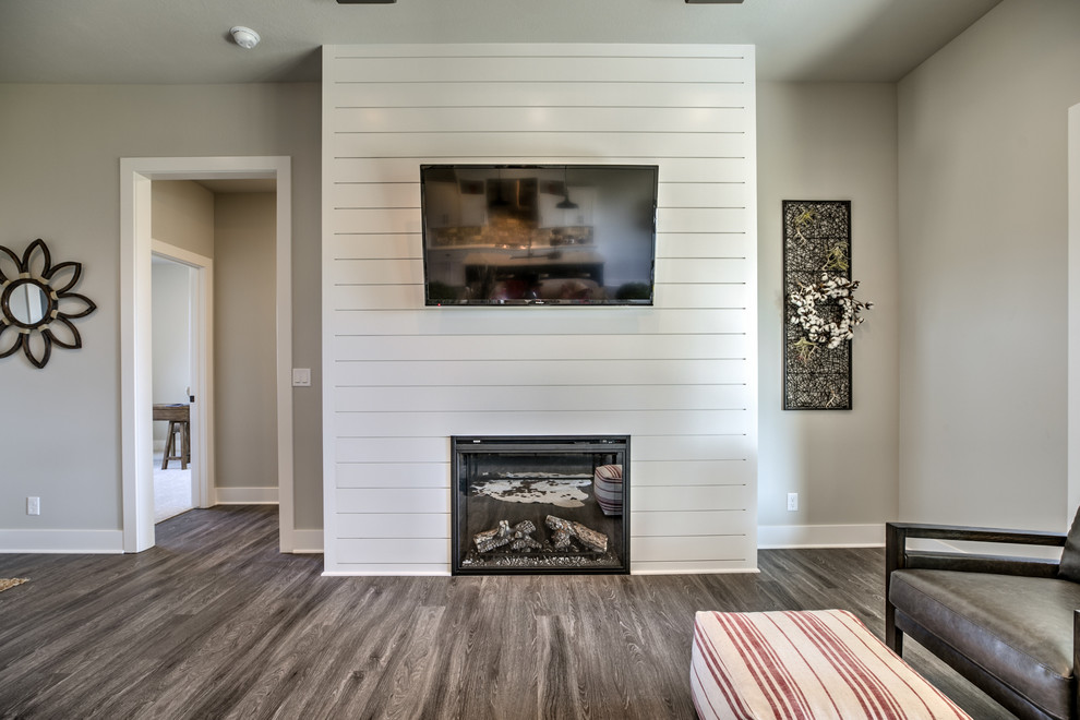 Imagen de sala de estar abierta de estilo americano con todas las chimeneas, marco de chimenea de madera y televisor colgado en la pared