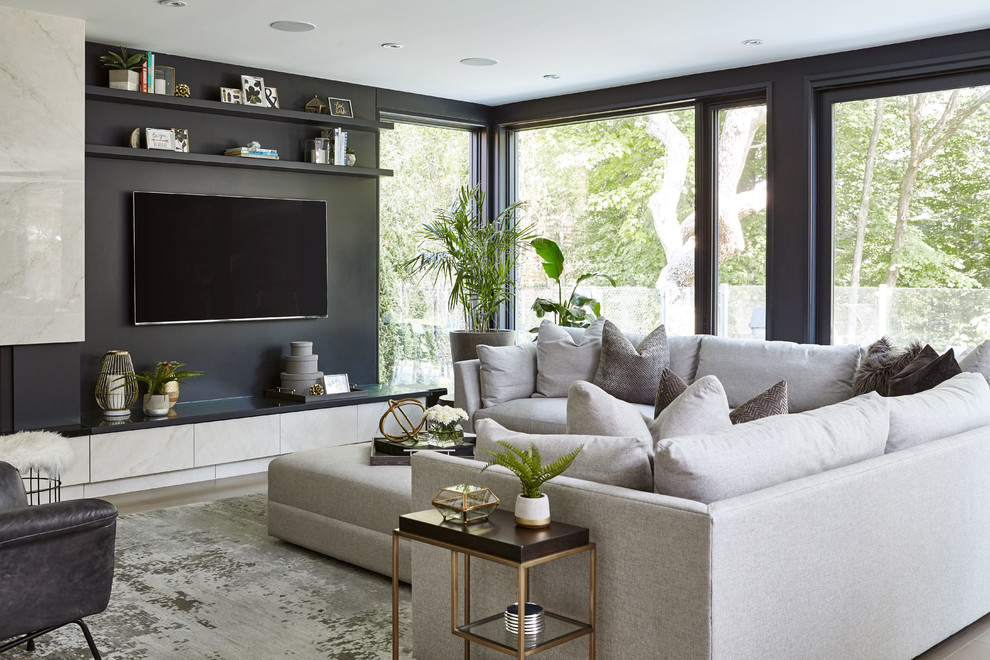 Modelo de sala de estar actual con paredes negras, suelo de madera clara, televisor colgado en la pared y suelo marrón