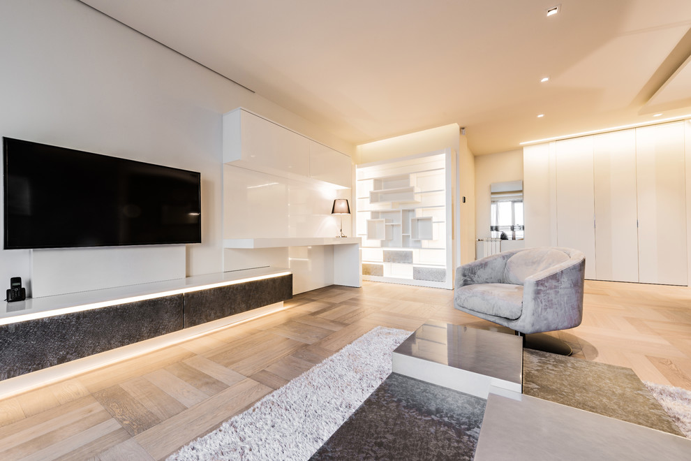 Diseño de sala de estar abierta minimalista extra grande sin chimenea con paredes blancas, suelo de madera clara, televisor colgado en la pared y suelo marrón