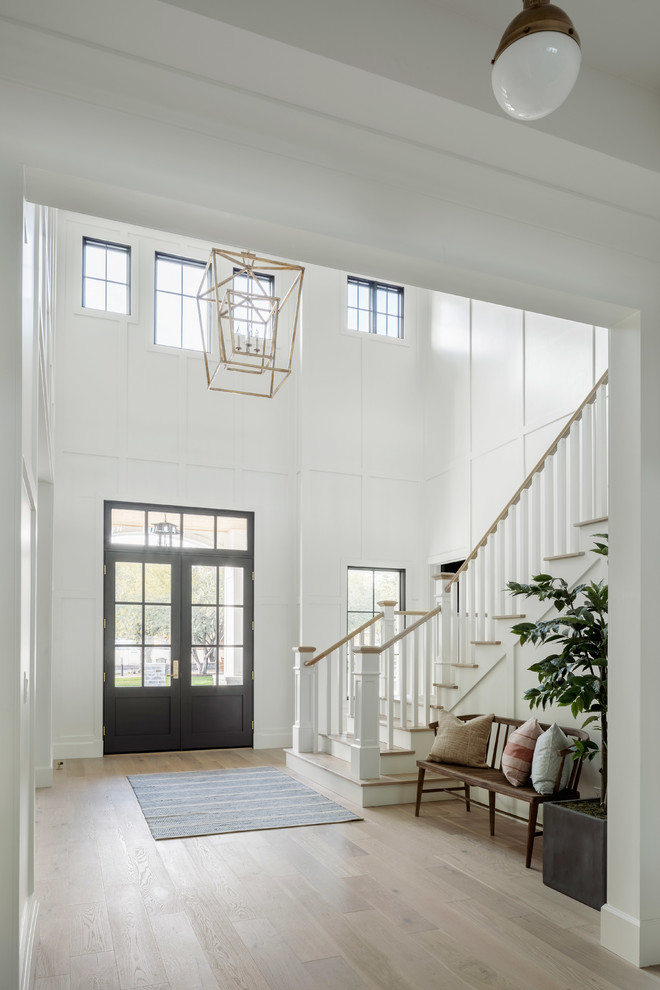 This is an example of a large farmhouse mezzanine games room in Phoenix with a game room, white walls, light hardwood flooring, a standard fireplace, a brick fireplace surround, a wall mounted tv and beige floors.