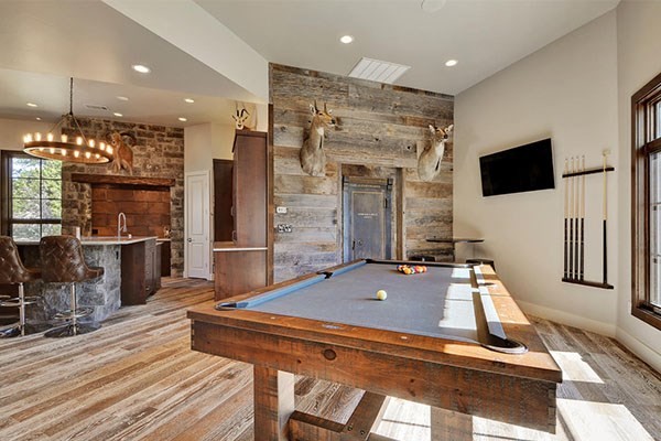 Foto de sala de juegos en casa abierta rústica grande con paredes blancas, suelo de madera en tonos medios y suelo marrón