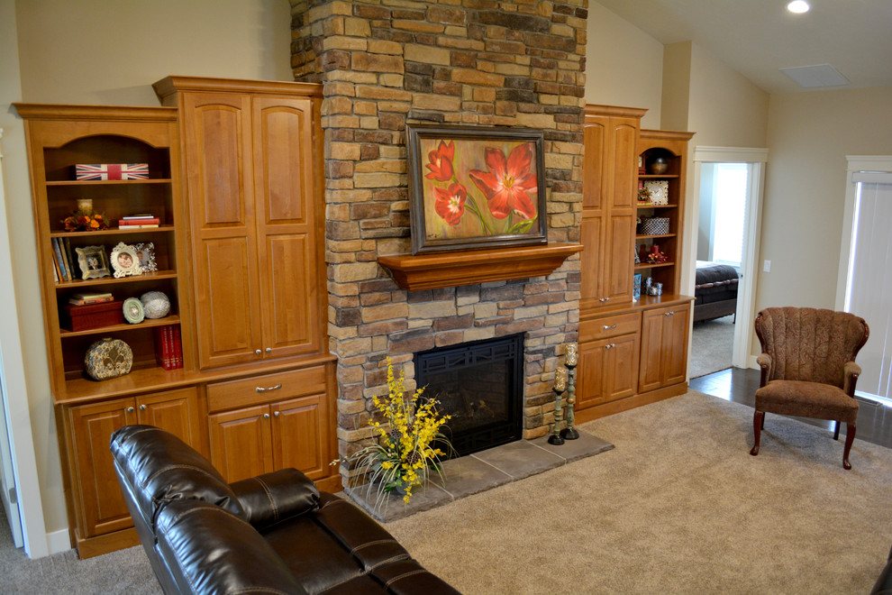 Imagen de sala de estar tradicional con moqueta, todas las chimeneas y marco de chimenea de piedra