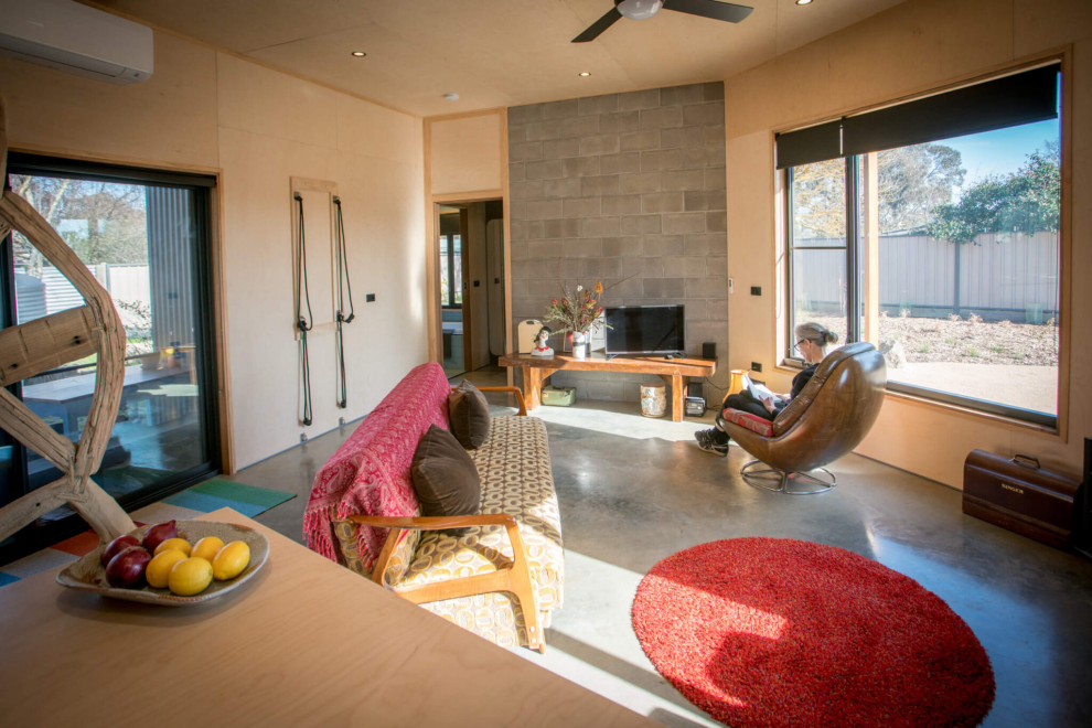 Стильный дизайн: маленькая открытая гостиная комната в современном стиле с бетонным полом, стандартным камином, отдельно стоящим телевизором, серым полом, потолком из вагонки и деревянными стенами для на участке и в саду - последний тренд