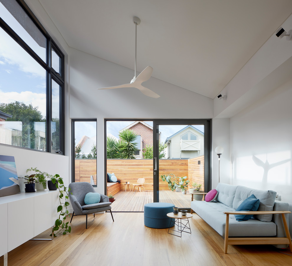 Mittelgroßes Modernes Wohnzimmer mit weißer Wandfarbe und hellem Holzboden in Melbourne
