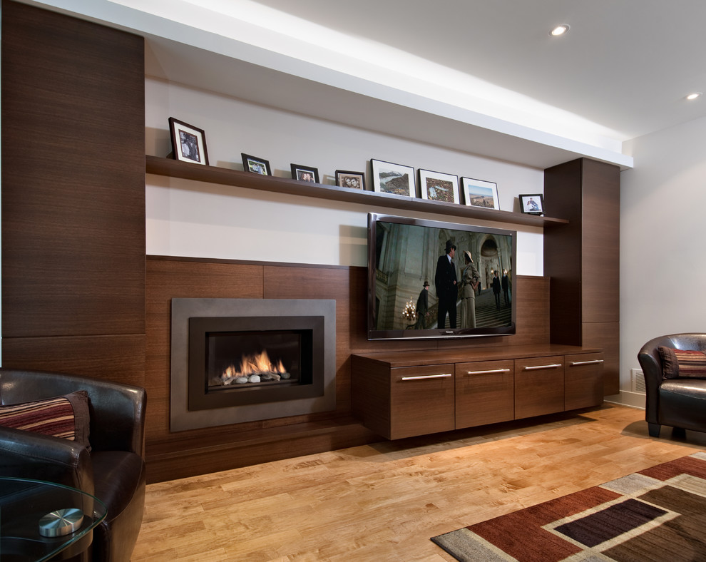 Inspiration for a large contemporary enclosed games room in Ottawa with white walls, light hardwood flooring, a standard fireplace, a metal fireplace surround, a wall mounted tv and beige floors.