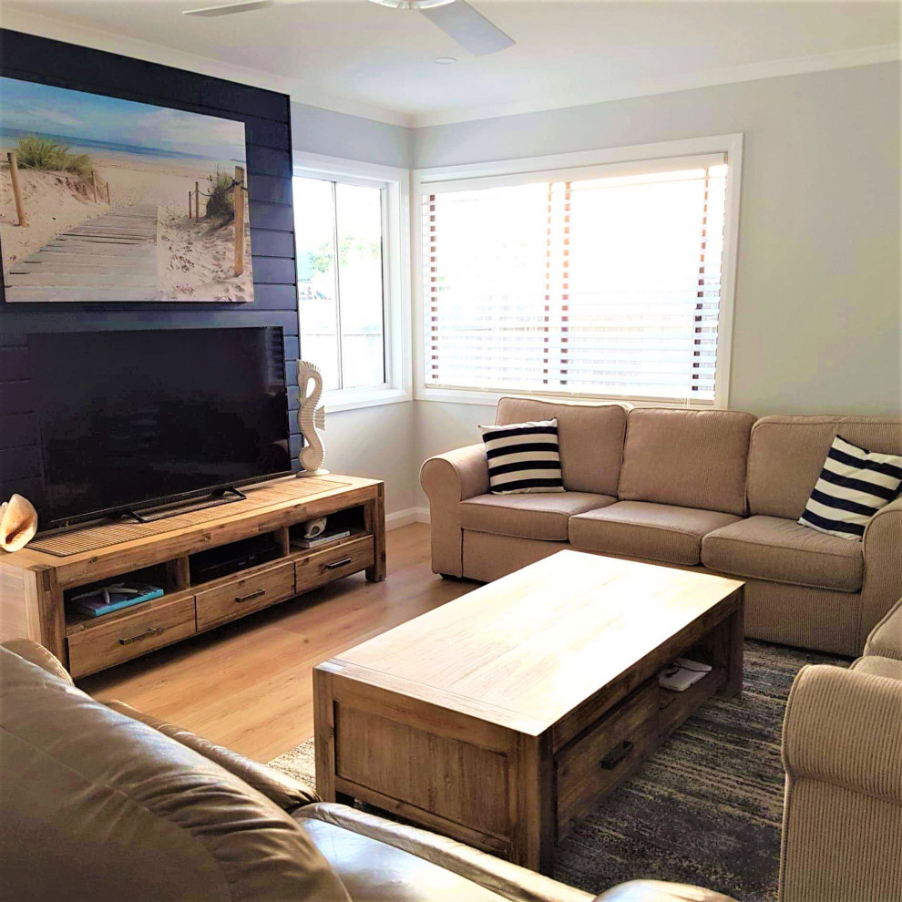 Cette image montre une salle de séjour design avec sol en stratifié et un téléviseur indépendant.