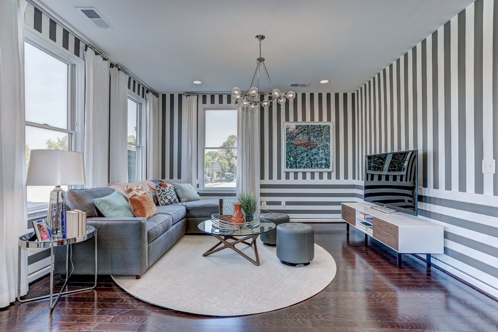 Modelo de sala de estar abierta tradicional renovada de tamaño medio sin chimenea con suelo de madera oscura, televisor independiente, suelo marrón y paredes multicolor