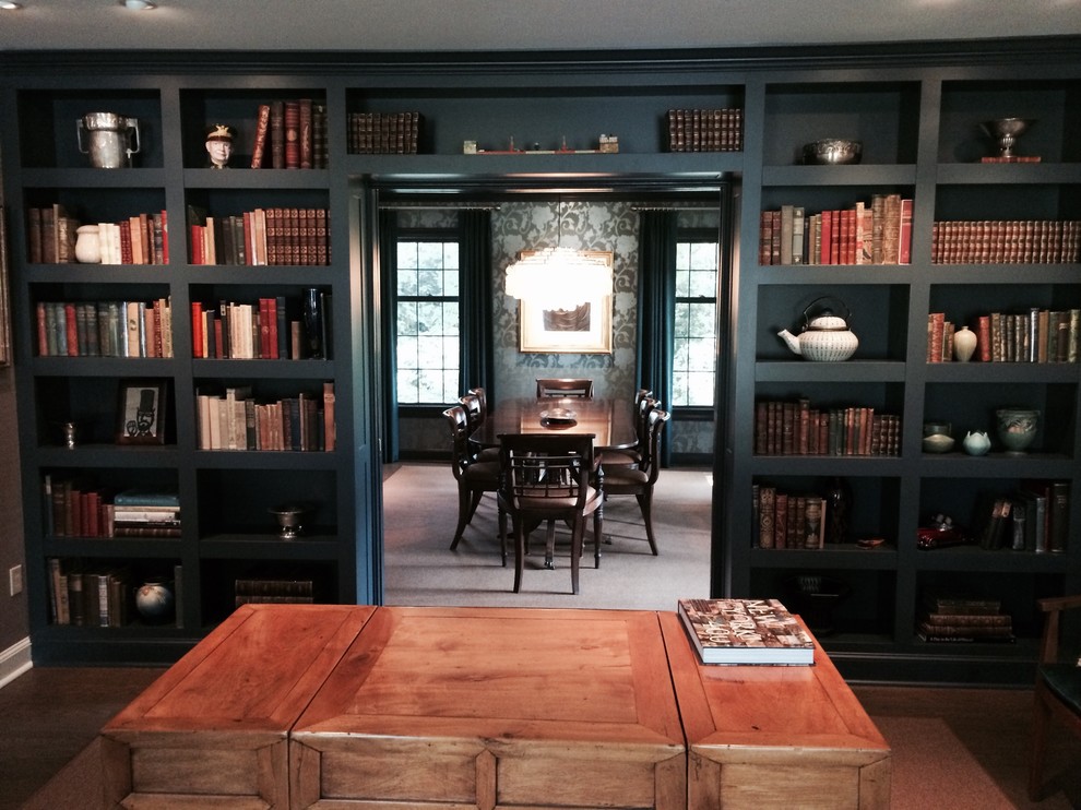 Cette image montre une salle de séjour bohème de taille moyenne et fermée avec une bibliothèque ou un coin lecture, un mur noir et parquet foncé.