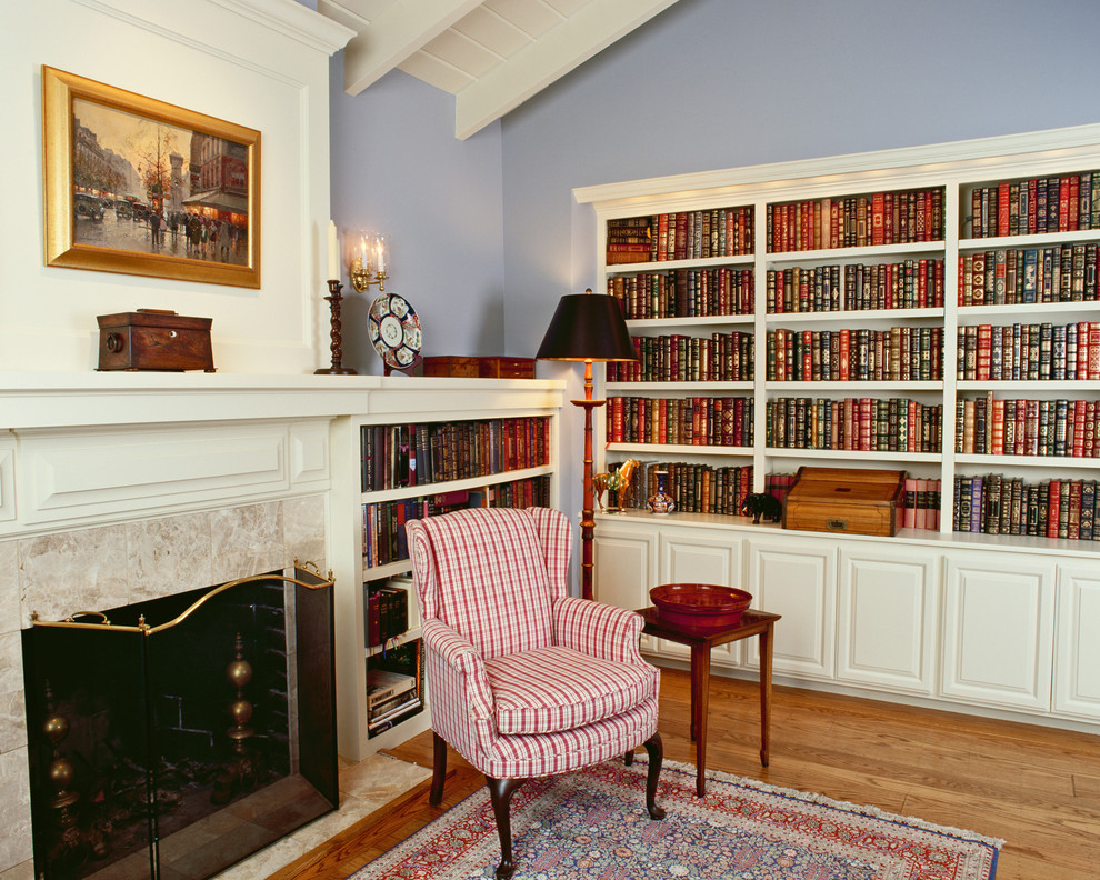 На фото: гостиная комната в классическом стиле с с книжными шкафами и полками с
