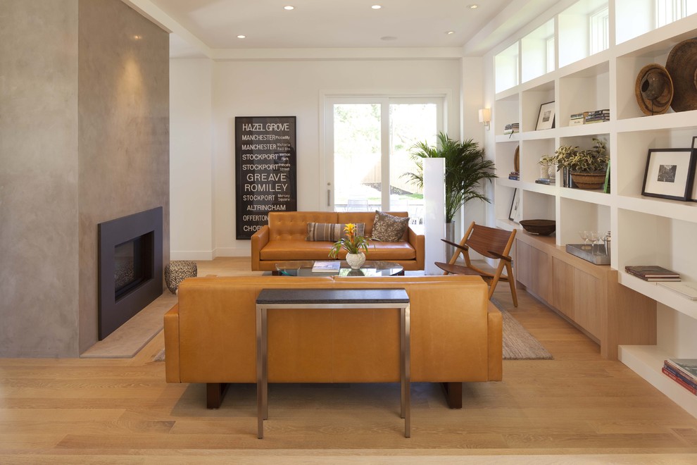 Example of a minimalist medium tone wood floor family room design in Minneapolis with white walls, a standard fireplace and no tv