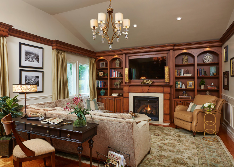 Example of a mid-sized transitional enclosed medium tone wood floor family room library design in New York with white walls, a standard fireplace, a stone fireplace and a wall-mounted tv