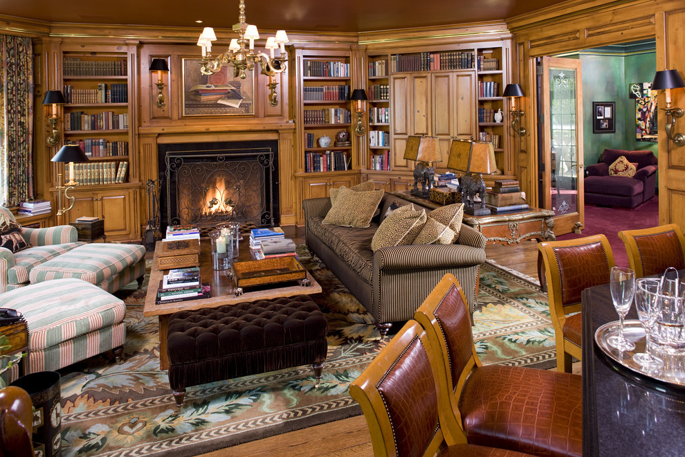 Imagen de sala de estar con biblioteca clásica con suelo de madera en tonos medios y todas las chimeneas