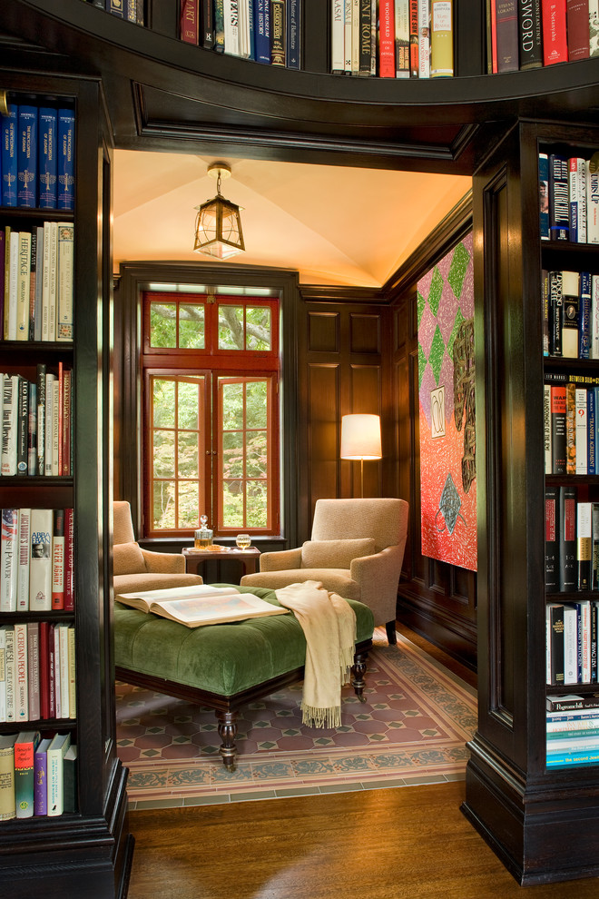 Aménagement d'une petite salle de séjour classique fermée avec un mur multicolore, une bibliothèque ou un coin lecture, parquet foncé et un sol marron.