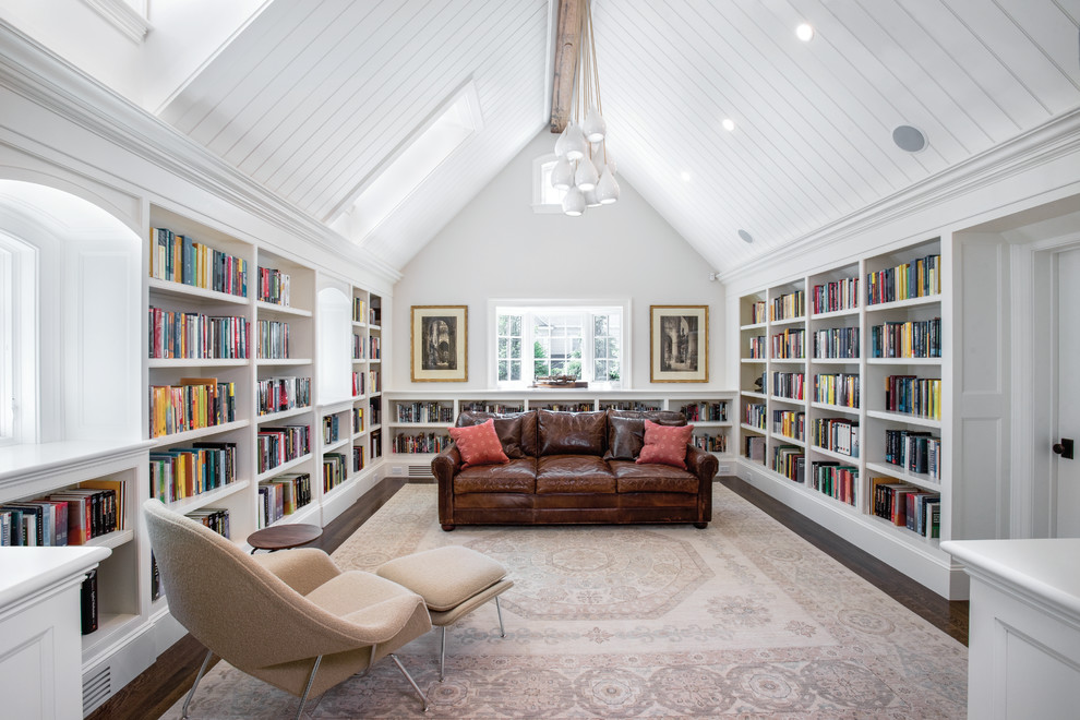 Aménagement d'une grande salle de séjour classique fermée avec une bibliothèque ou un coin lecture, un mur blanc, parquet foncé et un sol marron.