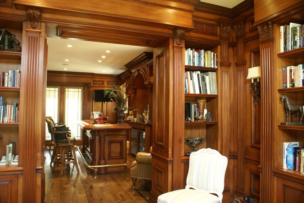Exempel på ett mellanstort klassiskt allrum med öppen planlösning, med en hemmabar, bruna väggar, ljust trägolv och en väggmonterad TV
