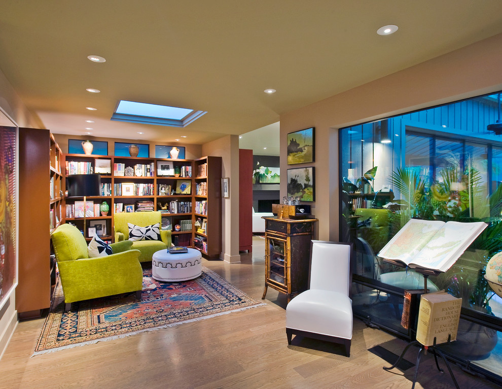 Immagine di un piccolo soggiorno bohémian aperto con libreria, pareti beige e pavimento in legno massello medio