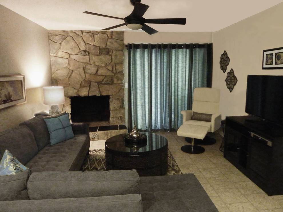 Пример оригинального дизайна: гостиная комната среднего размера в современном стиле с серыми стенами, стандартным камином, фасадом камина из камня и отдельно стоящим телевизором