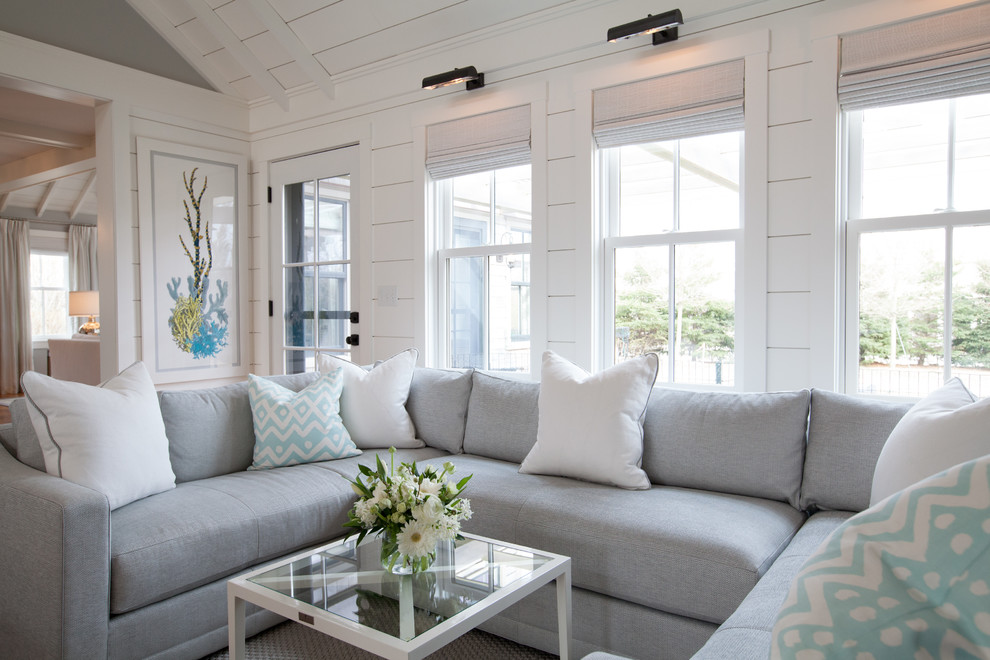 На фото: большая открытая гостиная комната в морском стиле с серыми стенами, стандартным камином и телевизором на стене с