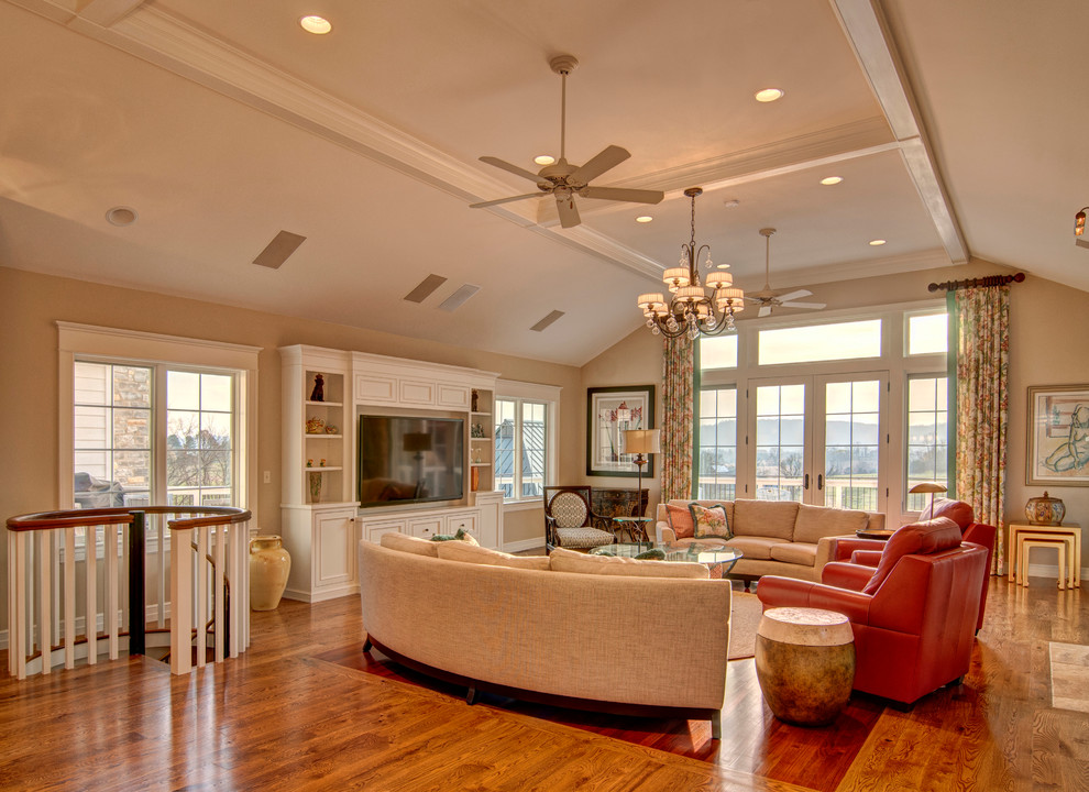 Ejemplo de sala de estar clásica con paredes beige, suelo de madera en tonos medios y pared multimedia