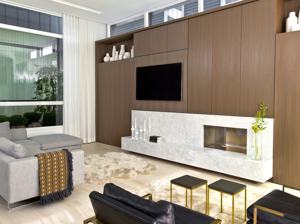 Ejemplo de sala de estar abierta contemporánea de tamaño medio con paredes blancas, suelo de madera clara, chimenea lineal y marco de chimenea de piedra