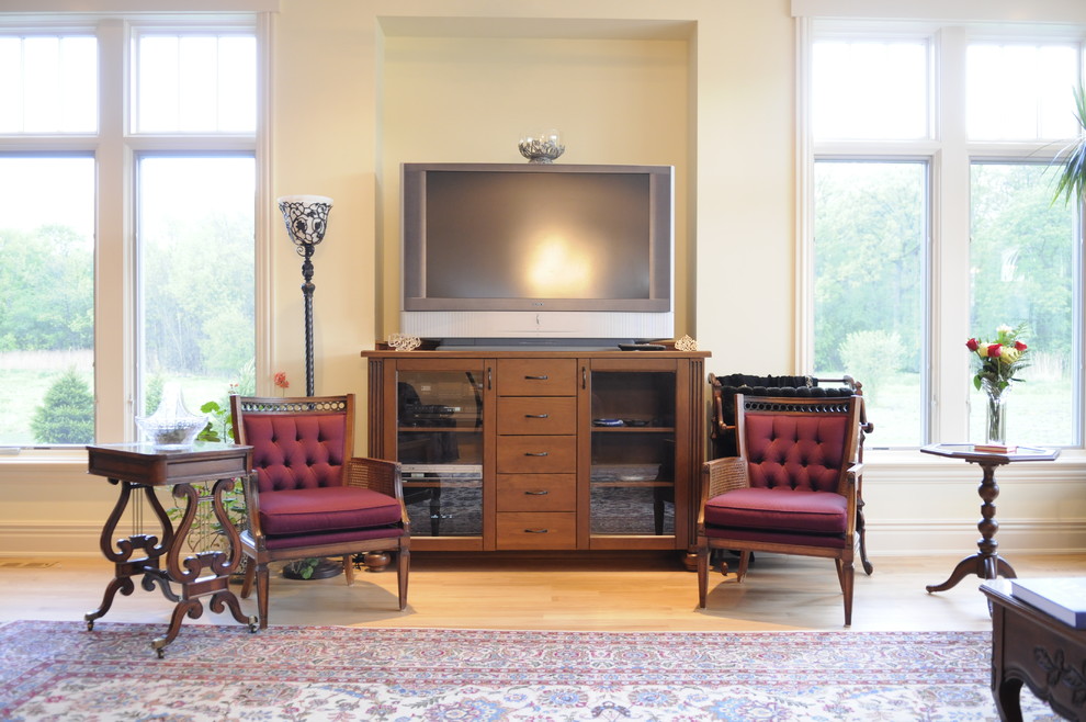 Exempel på ett mellanstort klassiskt avskilt allrum, med gula väggar, mellanmörkt trägolv och en fristående TV