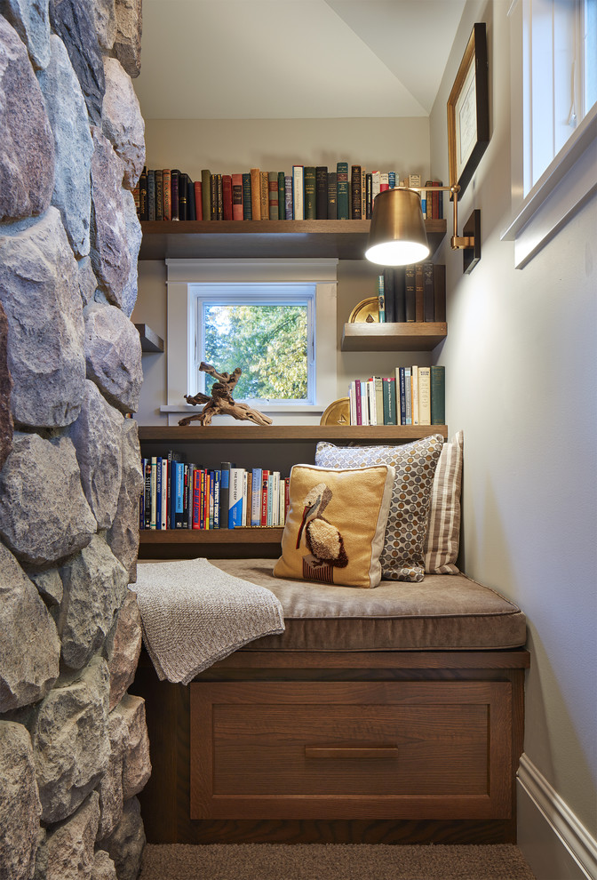 Cette image montre une petite salle de séjour marine avec une bibliothèque ou un coin lecture et un mur gris.