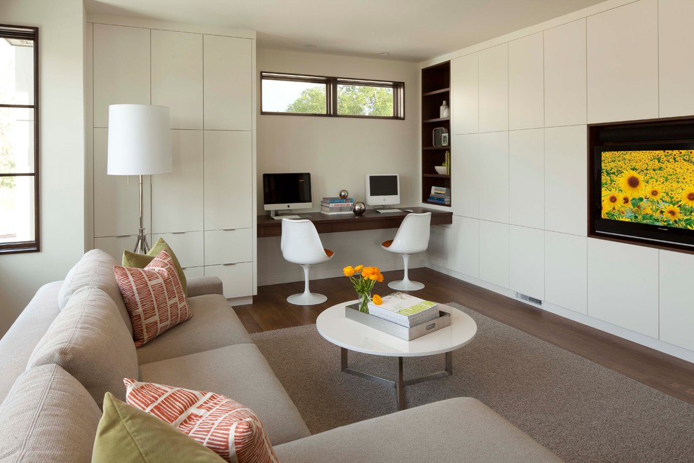 Imagen de sala de estar minimalista con paredes beige, suelo de madera oscura, pared multimedia y alfombra