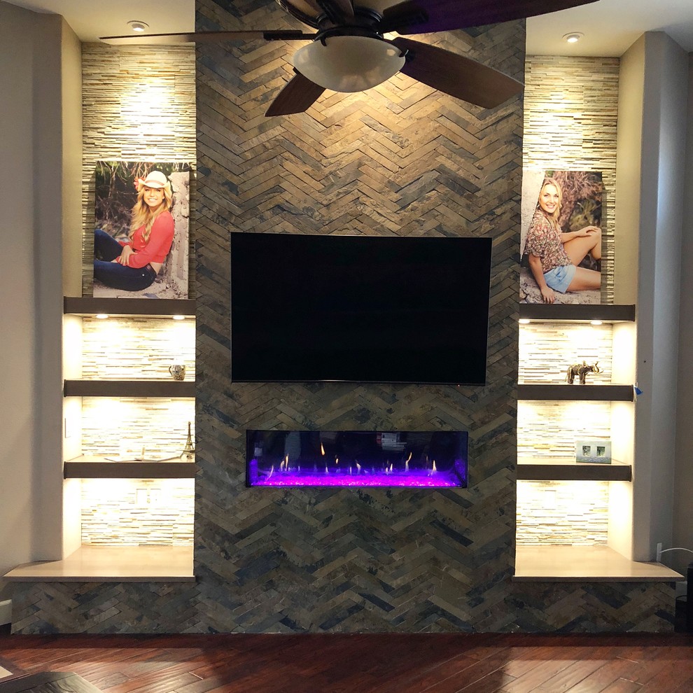 ラスベガスにあるお手頃価格のトラディショナルスタイルのおしゃれなオープンリビング (マルチカラーの壁、横長型暖炉、石材の暖炉まわり、壁掛け型テレビ) の写真