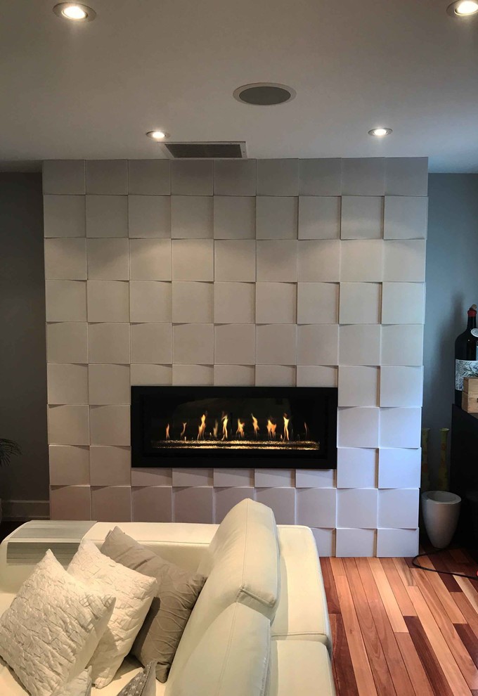 Inspiration for a medium sized contemporary games room in New York with medium hardwood flooring, a ribbon fireplace and a stone fireplace surround.