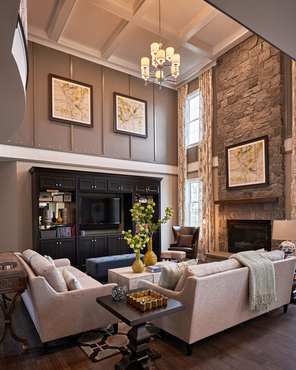 Aménagement d'une grande salle de séjour classique ouverte avec un mur gris, parquet foncé, une cheminée standard, un manteau de cheminée en pierre et un téléviseur encastré.