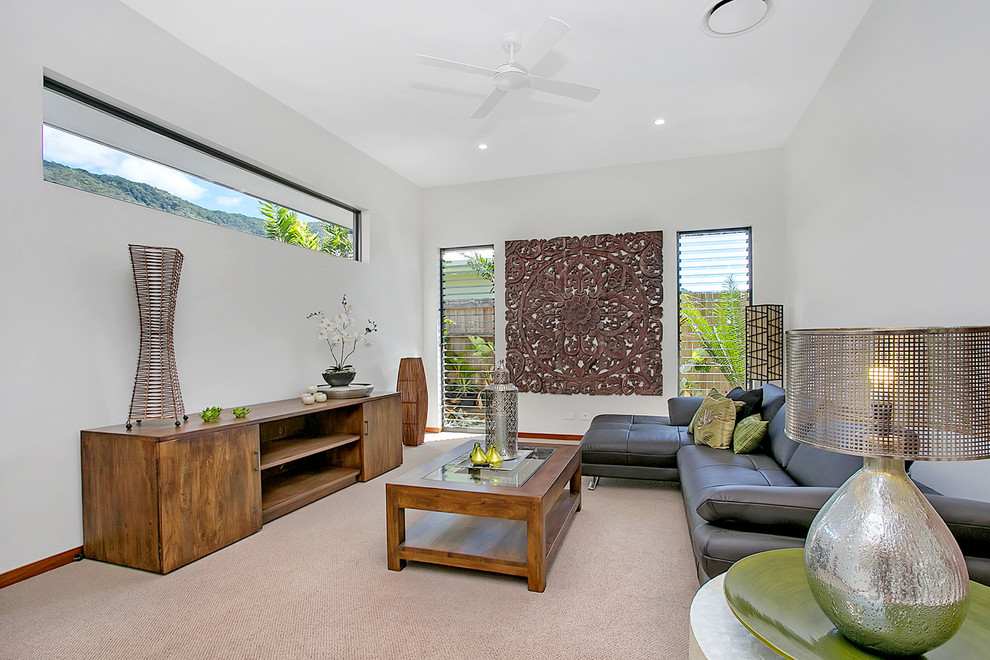 Imagen de sala de estar cerrada tropical de tamaño medio sin televisor con moqueta