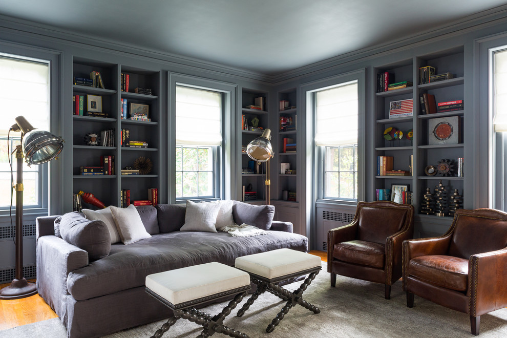 Foto di un soggiorno tradizionale di medie dimensioni e chiuso con libreria, pareti grigie, pavimento in legno massello medio e TV a parete