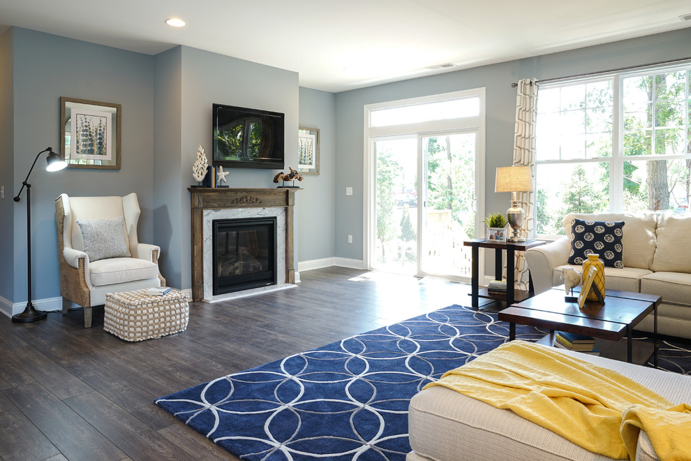 Immagine di un grande soggiorno stile marino aperto con pareti blu, pavimento in vinile, camino classico, TV a parete e cornice del camino in legno