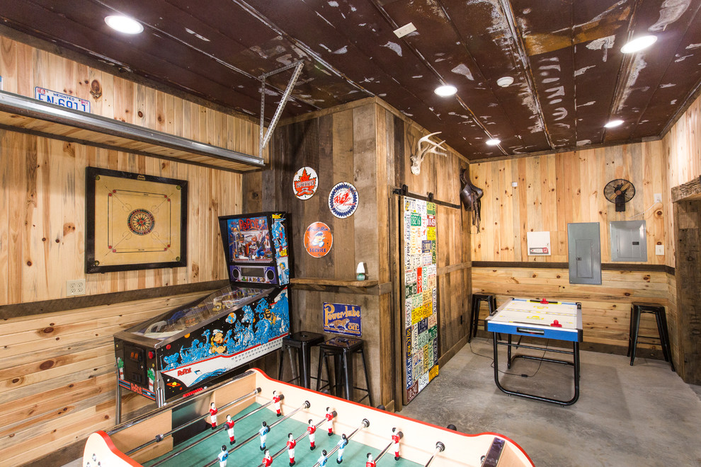 Rustic games room in Charlotte with concrete flooring and a game room.