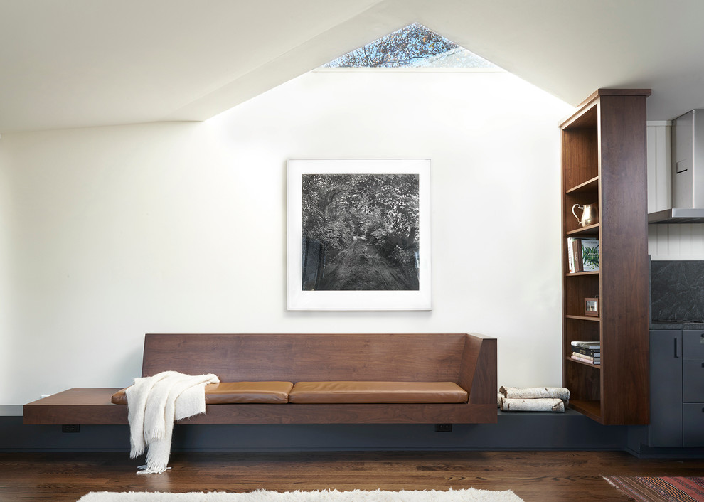 Inspiration pour une salle de séjour design avec un mur blanc et un sol en bois brun.