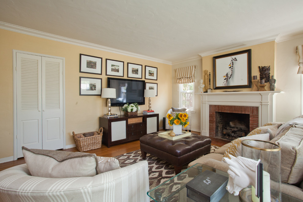 Réalisation d'une salle de séjour design de taille moyenne et fermée avec un mur jaune, un sol en bois brun, une cheminée standard et un téléviseur indépendant.