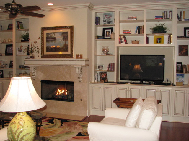 Cette image montre une salle de séjour traditionnelle de taille moyenne et ouverte avec un mur beige, parquet clair, une cheminée standard, un manteau de cheminée en carrelage, un téléviseur indépendant et un sol marron.