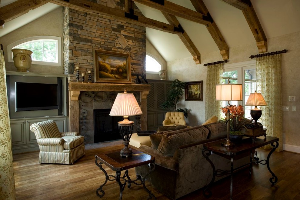 This is an example of a medium sized traditional open plan games room in Cincinnati with beige walls, light hardwood flooring, a built-in media unit, a standard fireplace and a stone fireplace surround.