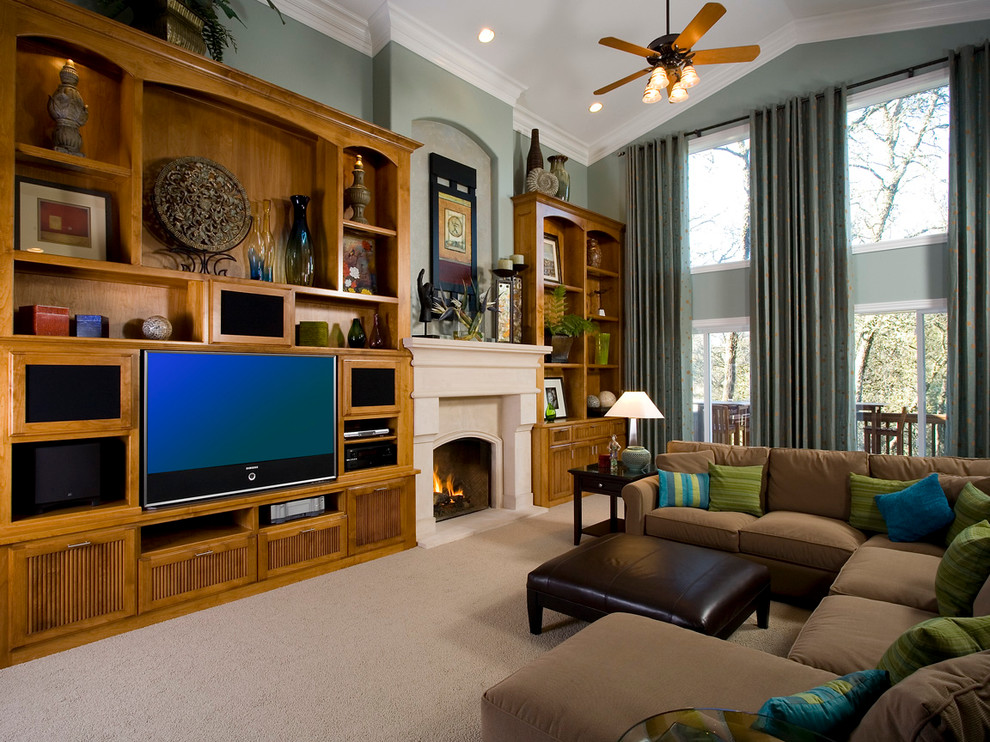 Cette image montre une salle de séjour traditionnelle ouverte avec un mur vert, moquette, une cheminée standard, un manteau de cheminée en pierre et un téléviseur encastré.