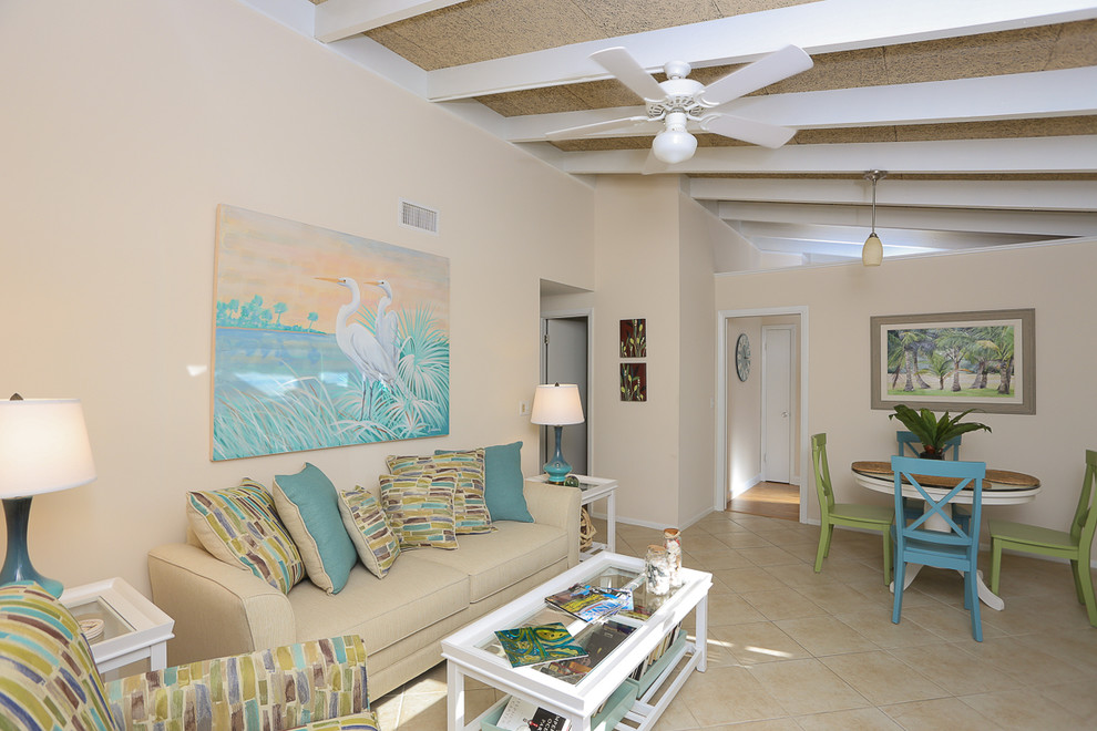 Offenes Maritimes Wohnzimmer ohne Kamin mit beiger Wandfarbe, Porzellan-Bodenfliesen und freistehendem TV in Tampa